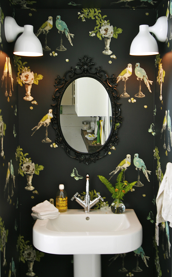 Black wallpaper with birds and florals in a modern bathroom